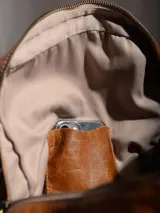 Mochila negra de cuero con cierre superior y dos bolsillos frontales con cierre.