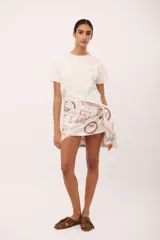 Pareo corto de tela estampada con motivos de frutas y textos.