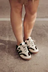 Zapatillas Adidas Samba con estampado animal print en blanco y negro, detalles en cuero beige y suela de goma color caramelo.