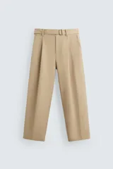 Pantalón color beige de corte ancho, con pliegues frontales, bolsillos laterales y traseros de ojal. Incluye cinturón de la misma tela con hebilla metálica.
