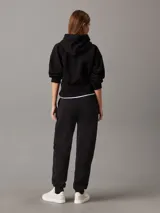 Pantalón de chándal negro de felpa de mezcla de algodón reciclado, corte regular, cintura elástica con cordón interior, puños de punto, bolsillos en la costura lateral y bordado en relieve Calvin Klein en la parte superior de la pierna.