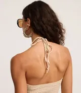 Blusa marrón oscuro con textura plisada, estilo frente única (halter) con escote en V profundo y lazo ajustable en el centro del busto. Presenta un ruedo con volado o efecto nube.