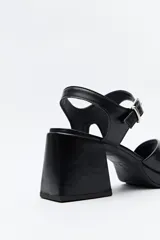 Sandalias negras con plataforma fina y taco ancho forrado. Incorporan pulsera con hebilla metálica y capellada ancha.