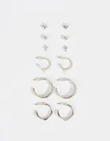 Set de aros plateados con seis pares de aros pasantes con diferentes diseños: bolitas, púas, cruces y argollas con púas, dobles y orgánicas.