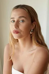 Aros tipo botón de acero quirúrgico hipoalergénico, con forma redondeada irregular y acabado brillante.