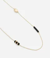 Collar largo dorado con abalorios de resina negra y dorada de diferentes formas.