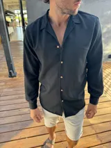 Camisa negra de manga larga con cuello clásico y botones color madera.