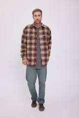 Sobrecamisa de hombre de manga larga con cierre de botones. Diseño a cuadros en tonos marrón, beige y verde. Confeccionada en tejido de sarga de lana, poliéster, acrílico y nylon.