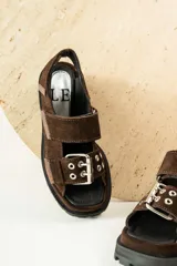 Sandalias de cuero color verde oliva con suela track y hebillas plateadas.