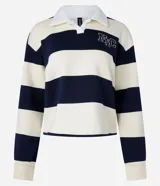 Suéter slim con cuello polo, manga larga y rayas horizontales en tonos crema y azul marino. Presenta lettering "NYC" bordado en el pecho y está confeccionado en algodón con forro fleece.