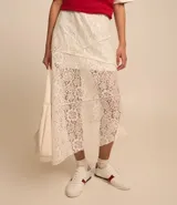 Pollera midi evasé de encaje color blanco, con cintura elástica, forro corto y bajo asimétrico.