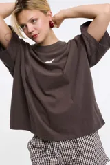 Remera blanca de algodón con cuello redondo y manga corta. Estampado pequeño de un ají rojo en el centro del pecho.