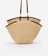 Bolso de playa tipo tote de paja natural con asas de cuero sintético marrón, forro interior y bolsillo interno.