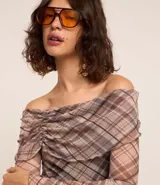 Blusa de tule con estampado de cuadros, escote hombro a hombro, mangas largas acampanadas y canesú fruncido.