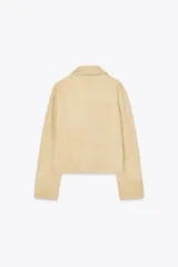 Chaqueta de mujer realizada en piel de ante color beige. Tiene cuello solapa, manga larga, bolsillos de plastrón en delantero y cierre frontal con botones.