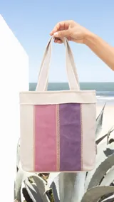 Bolsa matera de tela canvas combinada con división interna para organizar termo y mate. Incluye asa corta de mano.