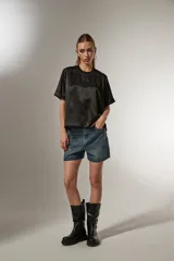 Blusa negra de poliéster con cuello redondo y corte ancho.