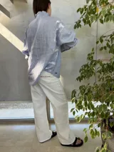 Camisa blanca de lino con cuello de volado y botones personalizados en los puños. Estampado con letras rojas en la espalda.