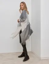 Ruana tejida con diseño colorblock en tonos borgoña, rosa viejo y beige. Presenta flecos en los bordes.