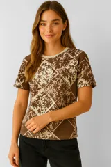 Remera de manga corta color marrón con estampado de flores en tonos beige y marrón oscuro, corte holgado y cuello redondo.