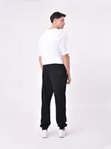 Pantalón de jogging negro con cintura elástica y cordón ajustable. Corte holgado con puños elásticos en los tobillos.