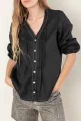 Camisa de jean celeste con cuello mao, abotonada al frente y mangas 3/4 con puños elásticos.