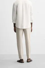 Pantalón de vestir color beige claro, de corte recto y confeccionado en lino.