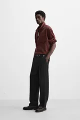Camisa color borgoña de corte relajado, confeccionada en tejido con mezcla de viscosa. Tiene cuello solapa, manga larga con puños abotonados, bolsillo de parche en el pecho y cierre frontal con botones.