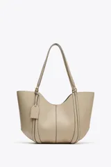 Bolso de hombro tipo shopper color beige, con doble asa y cierre imantado. Incluye una cartera interior con cierre de cremallera.