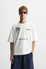 Camiseta negra de corte holgado, cuello redondo y manga corta. Estampado frontal con la frase "Take the risk or lose the chance" en color blanco.