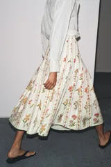 Falda midi de tiro medio confeccionada en hilatura de algodón. Tejido con tablas y estampado floral. Bajo acabado en vivo a contraste. Cierre lateral con cremallera oculta en costura.
