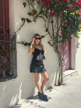 Minifalda negra de cuero sintético con volados y tachas plateadas.