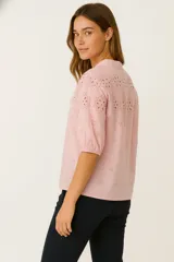 Camisa blanca de algodón con bordado calado tipo broderie, cuello mao, mangas 3/4 abullonadas y cierre frontal con botones.