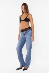 Pantalón denim azul de tiro bajo y pierna angosta. Cierre metálico con botón personalizado, cinco presillas, plastisol de marca en espalda y bolsillos laterales con relojero y remaches. Lavado azul con bigotes láser artesanales.