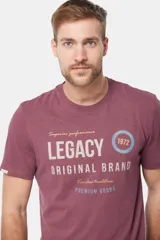 Remera de manga corta color borgoña con cuello redondo y estampado frontal con la leyenda "Legacy Original Brand" en color gris y un círculo con el número "1972" en azul.