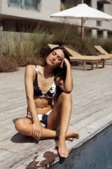 Conjunto de bikini turquesa con textura acanalada, compuesto por un corpiño triangular con argolla central y una bombacha vedetina con argollas en los laterales.