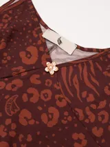 Vestido largo hasta el tobillo de viscosa y poliamida, con estampado de rayas verticales rosas y flores rojas. Tiene breteles finos, escote en V profundo y detalle de flor Polonio en cobre.