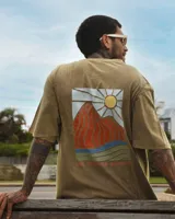 Remera verde oliva de manga corta con cuello redondo y estampado en el pecho de un sol sobre montañas.