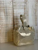 Mini bag tipo limosnera color negro charolado, con asa corta superior.