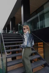 Pantalón ancho verde oliva con bolsillos cargo y aplique de cinta con rayas blancas en los laterales.