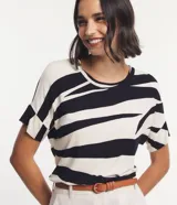Blusa de viscosa color crudo con estampado abstracto en negro. Tiene cuello redondo y mangas cortas con recorte.