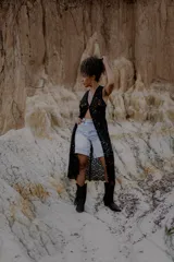 Chaleco largo calado color blanco, tejido al crochet, sin mangas y con caída fluida.