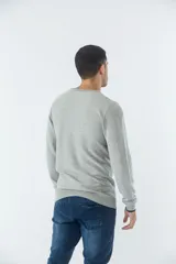 Sweater negro de algodón con cuello redondo y logo bordado en el pecho.