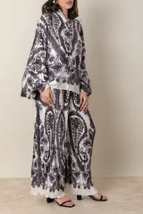 Pantalón palazzo de poliéster con estampado floral en tonos beige y rosa, cintura elastizada y corte plisado.
