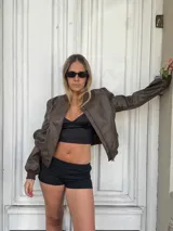 Campera bomber marrón de cuero sintético con cierre frontal y puños elastizados.