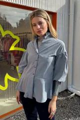 Camisa celeste con cuello mao con volados, mangas abullonadas 3/4 y corte peplum.