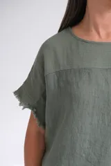Remera verde musgo de lino italiano, con escote a la base, corte amplio y mangas cortas con detalle desflecado.