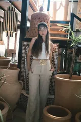 Pantalón de vestir negro de tiro alto, corte recto y pierna ancha. Presenta pliegues frontales y bolsillos laterales.