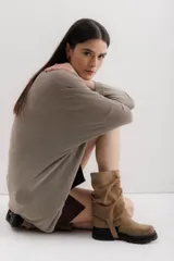 Bota de caña media color marrón claro, de gamuza con efecto arrugado, suela track y detalle de tira lateral con hebilla.