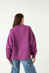 Buzo gris oscuro de algodón y poliéster con calce amplio y estampa frontal en color rosa con relieve.